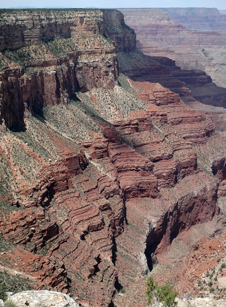 Layered rock strata in the Grand Canyon, distinct horizontal bands stacked over an immutable base
