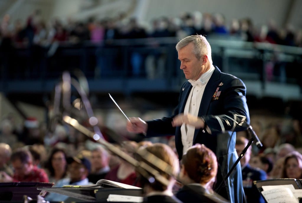 A conductor leading an orchestra — a generalist orchestrator coordinating specialists