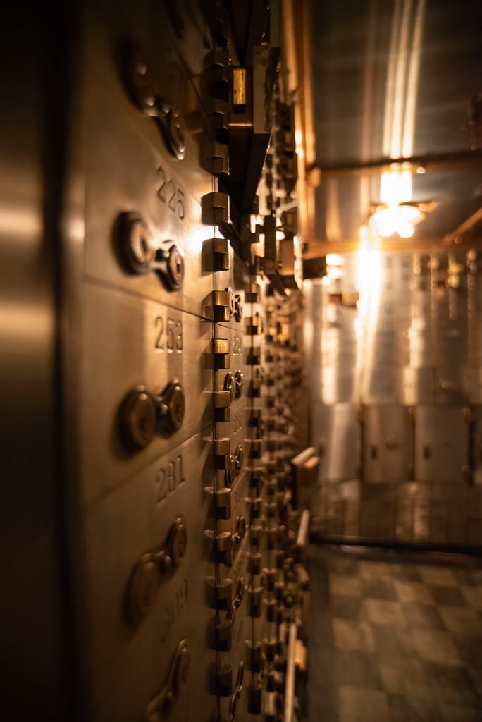 Rows of individually locked safe deposit boxes in a bank vault — each tenant sealed off from the others.
